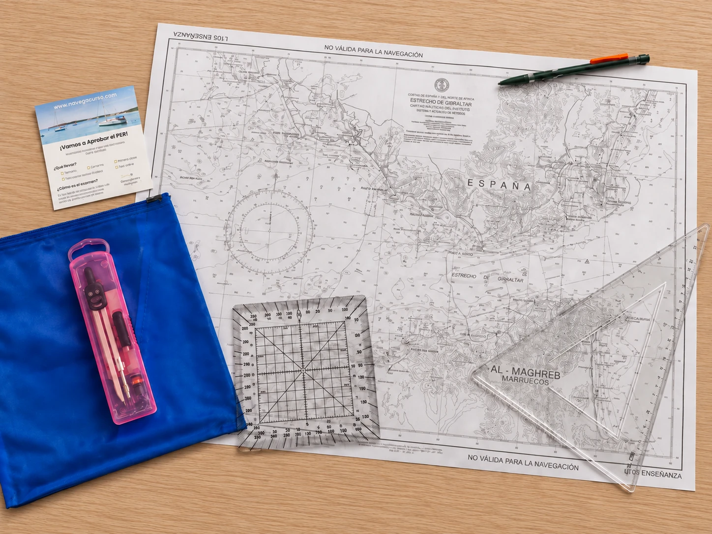 Kit del PER sobre una mesa: carta náutica L-105, transportador, cartabón, compás en su estuche, portaminas y funda azul